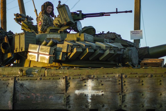 Ukrainian servicemen drive a tank as they cross Oskil village, Ukraine, Thursday, Oct. 6, 2022. (AP Photo/Francisco Seco)