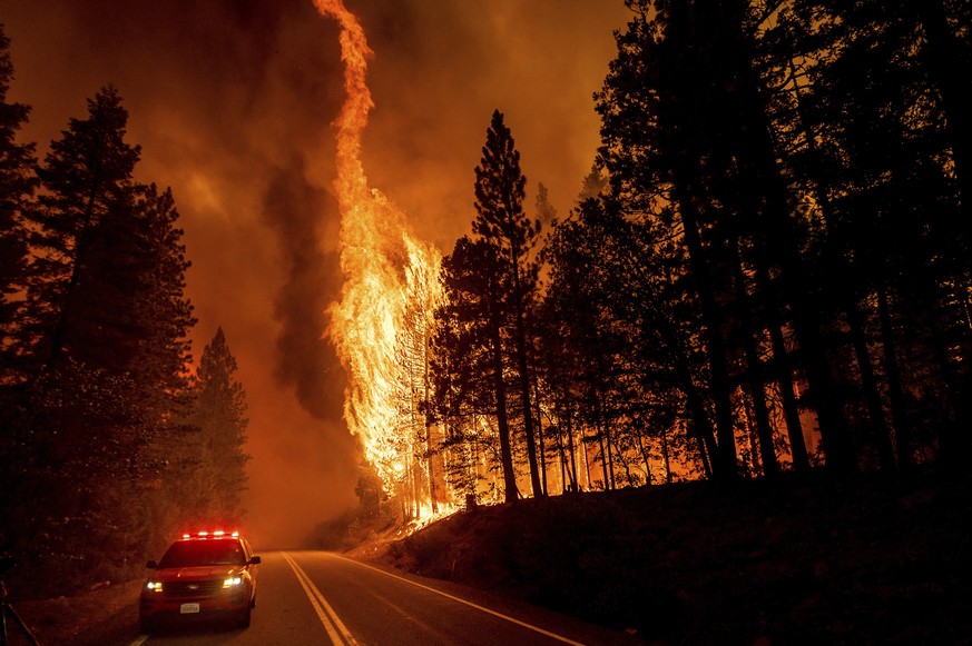 FILE - Flames leap from trees as the Dixie Fire jumps Highway 89 north of Greenville in Plumas County, Calif., on Aug. 3, 2021. A former college professor was indicted by a federal grand jury, Thursda ...