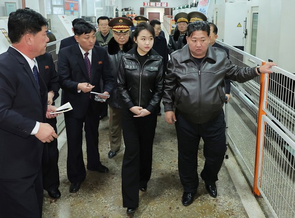 In this photo provided by the North Korean government, its leader Kim Jong Un, right, and his daughter visit a factory producing pistols and other light arms at an undisclosed place in North Korea Wed ...