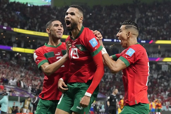 Morocco&#039;s Youssef En-Nesyri, center, celebrates after scoring his side&#039;s first goal during the World Cup quarterfinal soccer match between Morocco and Portugal, at Al Thumama Stadium in Doha ...