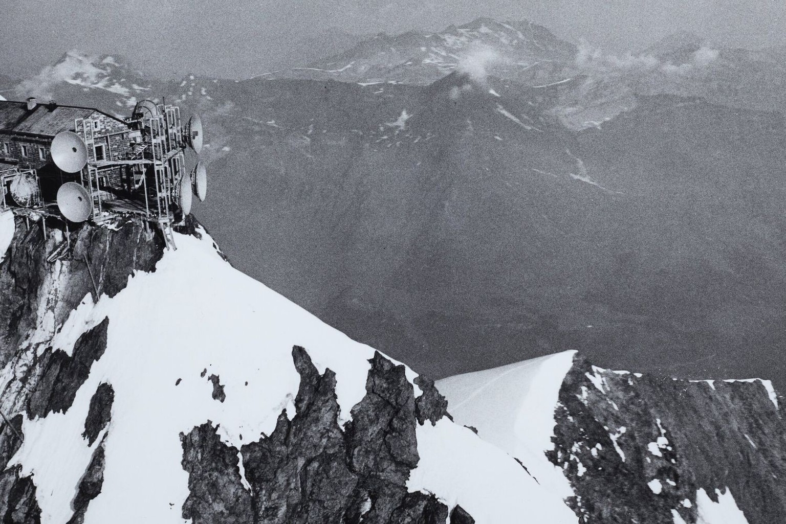 Vue aérienne de la station radio du Jungfraujoch en 1963. C’est par ce relais que les images de télévision franchissent les Alpes. D’autres faisceaux hertziens servent au téléphone, ce qui permet de d ...