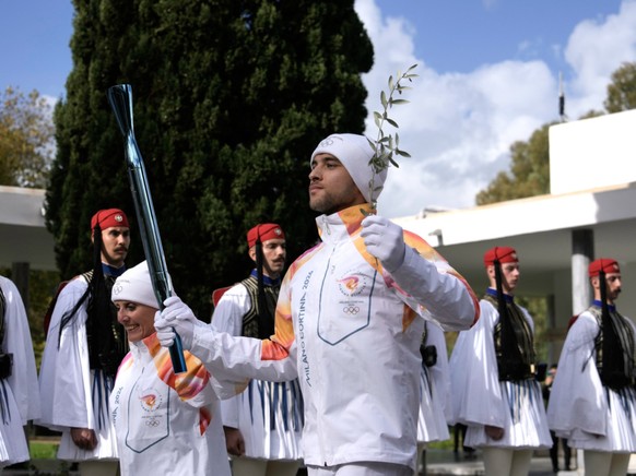 Le rameur grec Petros Gaidatzis (à droite) et la fondeuse italienne Stefania Belmondo ont lancé le relais de la flamme olympique.