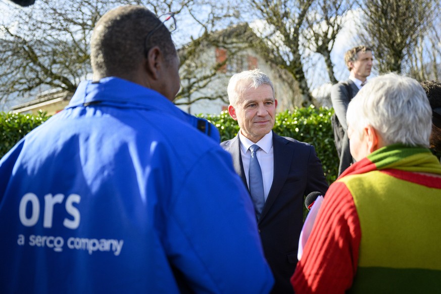 Le conseiller federal Beat Jans, centre, parle avec Mahamat Abdelkerim, gauche, coordinateur mediateur suisse romande de ORS alors qu&#039;ils marchent entre le centre federal pour requerants d&#039;a ...