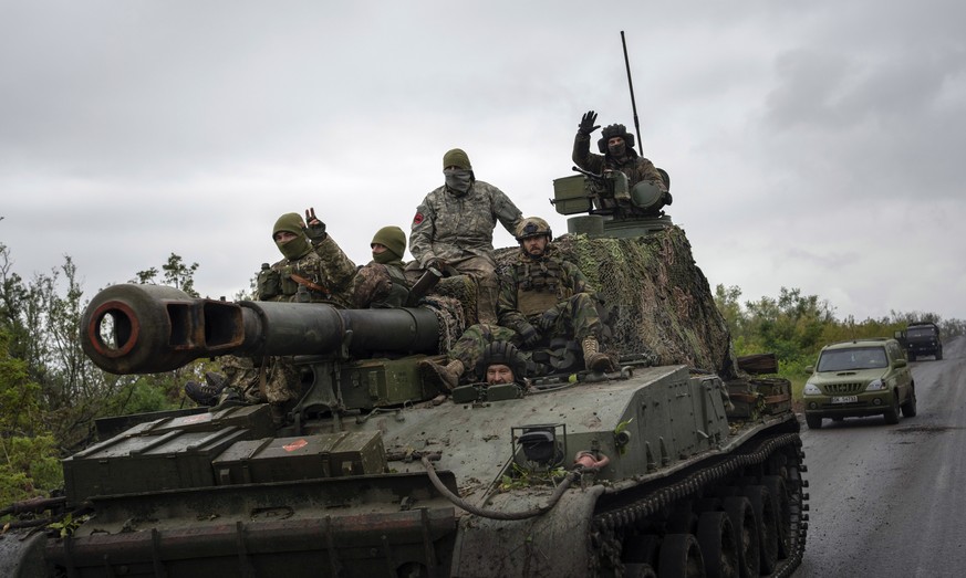 Ukrainian servicemen drive atop a self-propelled artillery vehicle in the recently retaken area of Dolyna, Donetsk region, Ukraine, Wednesday, Sept. 14, 2022. (AP Photo/Evgeniy Maloletka)