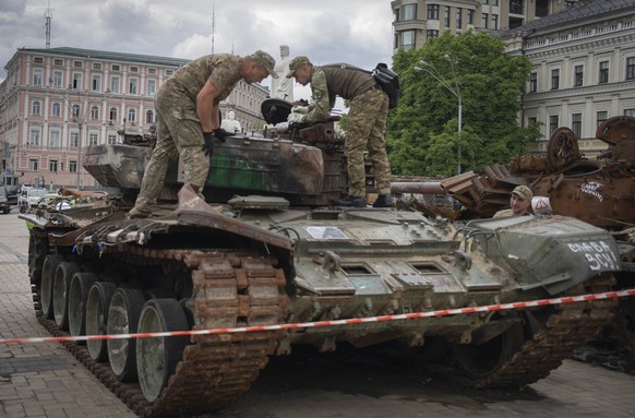 Sappers inspect a damaged Russian tank installed as a symbol of war in central Kyiv, Ukraine, Thursday, June 15, 2023. (AP Photo/Efrem Lukatsky)