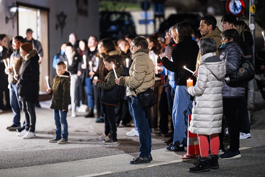 People attend a ceremony following the discovery of 5 ski tourers who had died near Tete Blanche in the Swiss alps mountains, in Vex, Switzerland, Monday, March 11, 2024. Five cross-country skiers who ...
