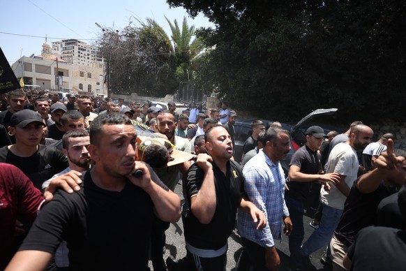 Des personnes en deuil portent des corps lors des funérailles des treize Palestiniens tués lors d'un raid de l'armée israélienne à Jénine en Cisjordanie, le 5 juillet.