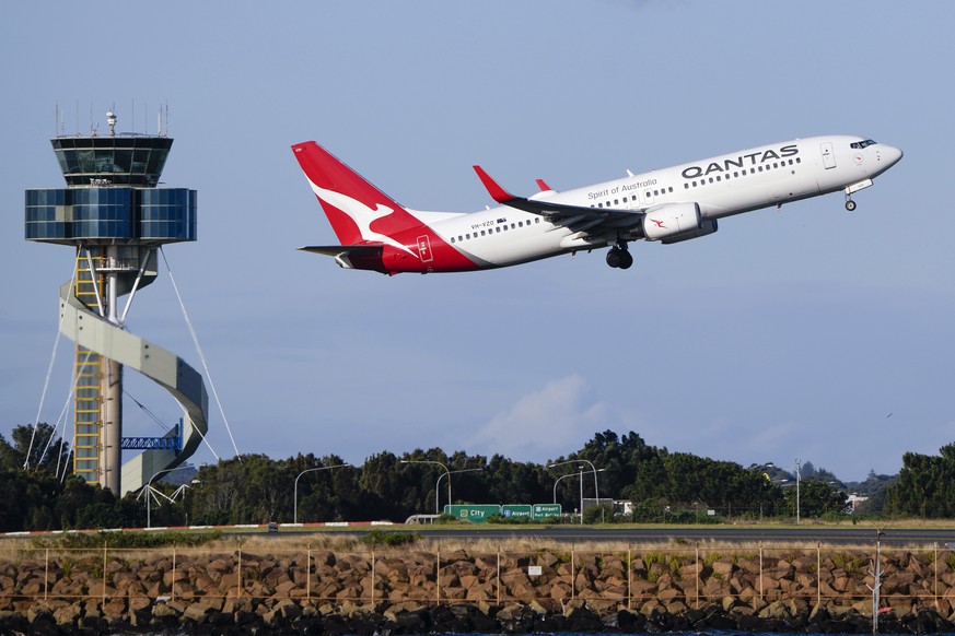 FILE - A Qantas Boeing 737 passenger plane takes off from Sydney Airport, Australia, on Sept. 5, 2022. Qantas Airways agreed to pay 120 million Australian dollars ($79 million) in compensation and fin ...