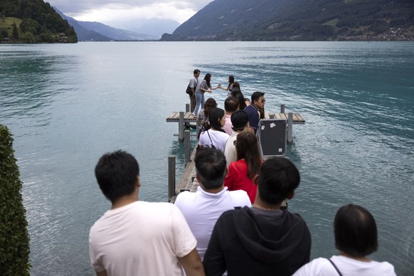 Korean visitors take pictures at the pier in Iseltwald, Switzerland, Tuesday, July 26, 2022. Lots of Asian TV fans and tourists visit the place because the romantic Korean Netflix drama &amp;#039;Cras ...