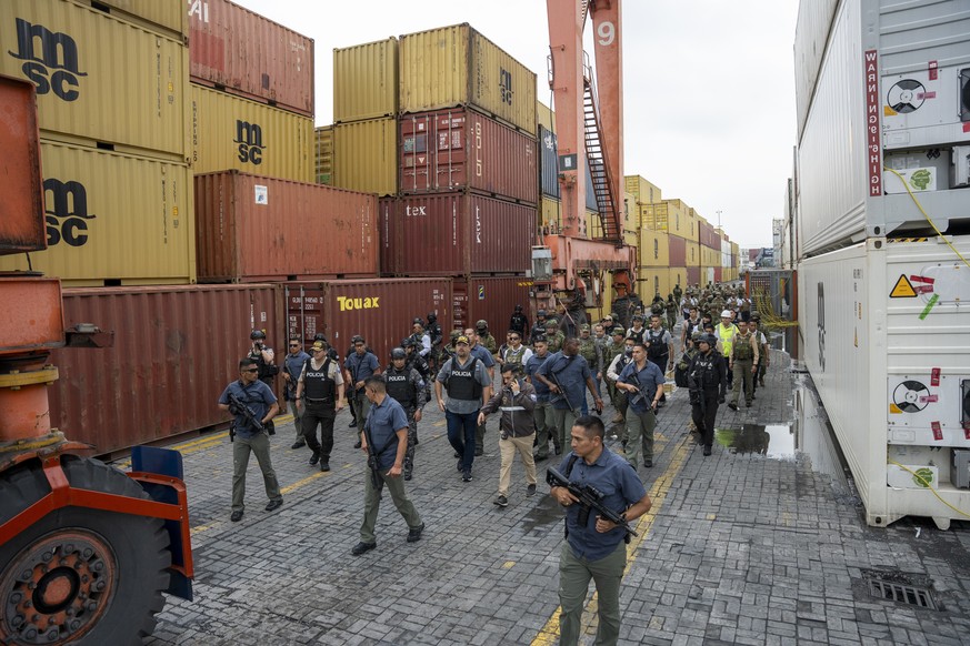 epa12652559 Ecuadorian police and military personnel inspect an area during a raid in Guayaquil, Ecuador, 15 January 2026. A large contingent of security forces carried out operations at the city?s po ...