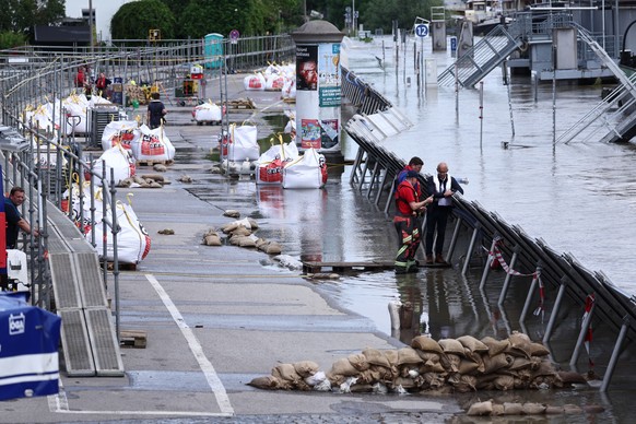 epaselect epa11389382 People work on a protective wall at the flooded Danube river in Regensburg, Germany, 04 June 2024. Flood levels continue to rise in the German states of Bavaria and Baden-Wuertte ...