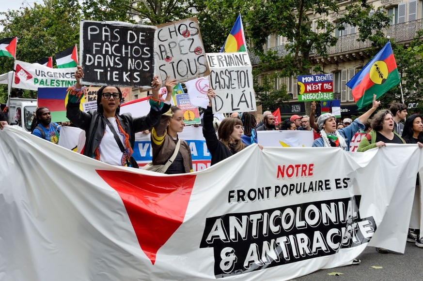 Manifestantes avec une banderole &quot;Notre front populaire est anticolonial et antiraciste&quot;, des pancartes &quot;Pas de fachos dans nos tieks&quot; et &quot;Le R-Haine casse toi d&#039;là !&quo ...