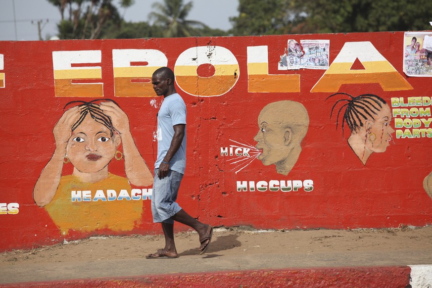 Un homme marche le long d'une peinture murale de prévention contre Ebola, au Liberia, en 2015.
