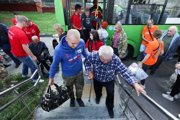 Russia: Evacuated residents of Kursk Region sent to temporary accommodation facilities RUSSIA, KURSK - AUGUST 17, 2024: A volunteer helps an evacuated resident of the Kursk Region s border district go ...