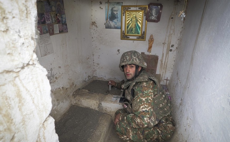 An Ethnic Armenian soldier lights a candle in a improvised chapel near a fighting position on the front line, during a military conflict against Azerbaijan&#039;s armed forces in the separatist region ...