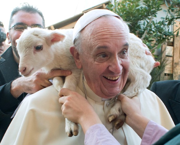 RETRANSMISSION OF OSS102 TO PROVIDE DIFFERENT CROP - In this photo provided by the Vatican paper L&#039;Osservatore Romano Tuesday, Jan. 7, 2014, Pope Francis is placed a lamb around his neck as he vi ...