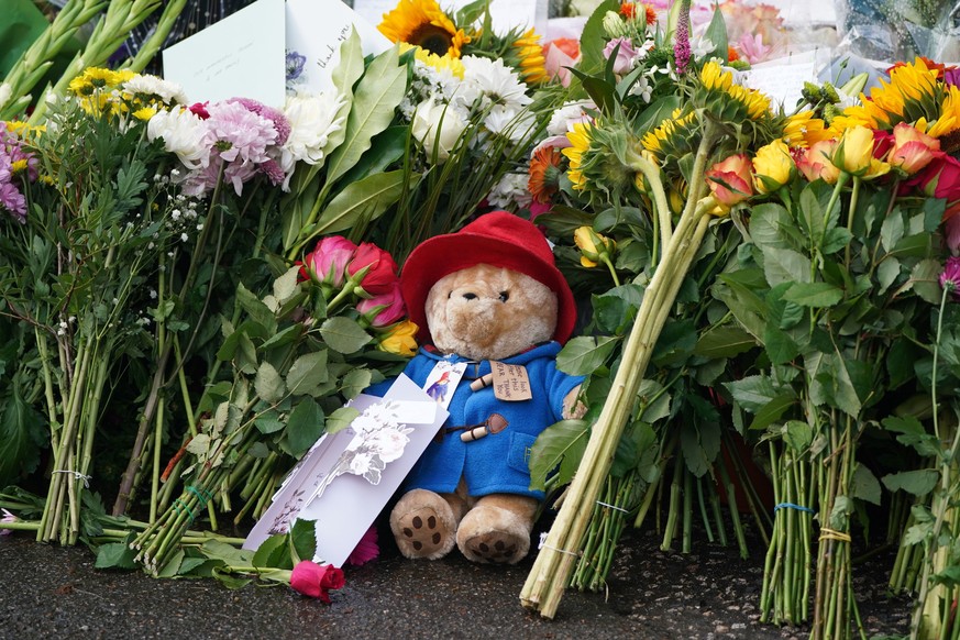 Floral tributes and a Paddington bear teddy are laid at the gates of Balmoral in Scotland, Friday, Sept. 9, 2022, following the death of Queen Elizabeth II on Thursday. (Andrew Milligan/PA via AP)