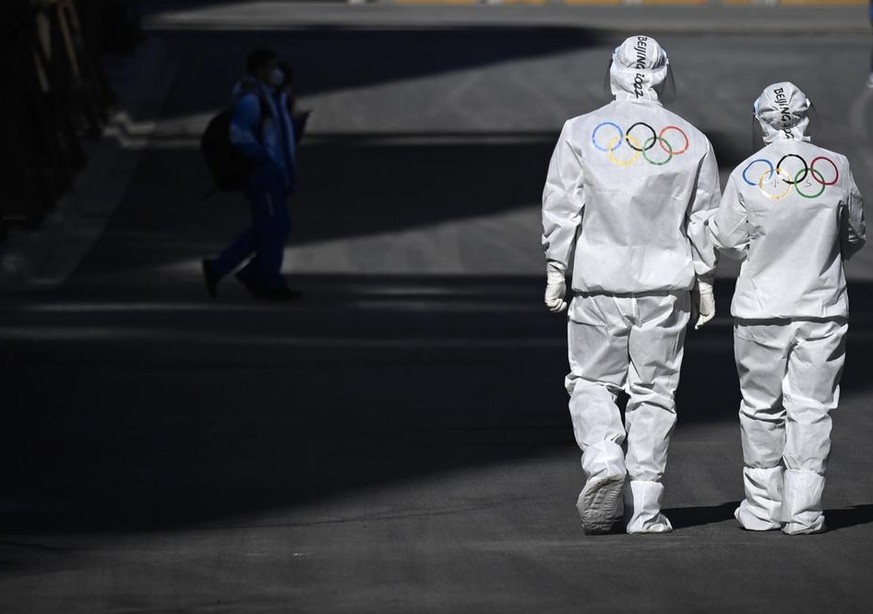 Olympic workers walk on a road at the Olympic Village ahead of the 2022 Winter Olympics, Tuesday, Feb. 1, 2022, in Beijing. (Wang Zhao/Pool Photo via AP)