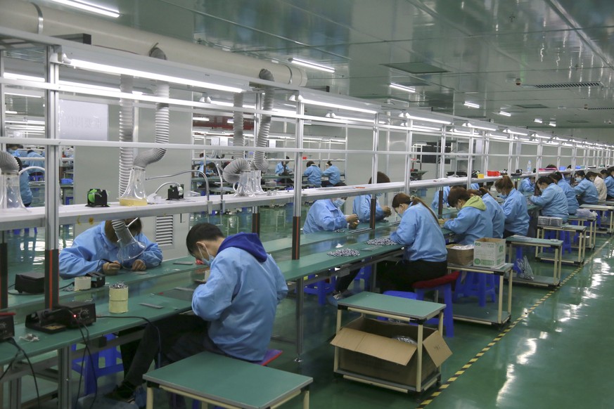 Workers put together electronic gears at a factory in Zhangye in northwestern China&#039;s Gansu Province on April 17, 2021. Two surveys show Chinese manufacturing expanded in April but growth appeare ...