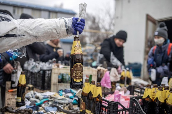 Dans une arrière-cour de Lviv, un groupe fabrique des cocktails Molotov.