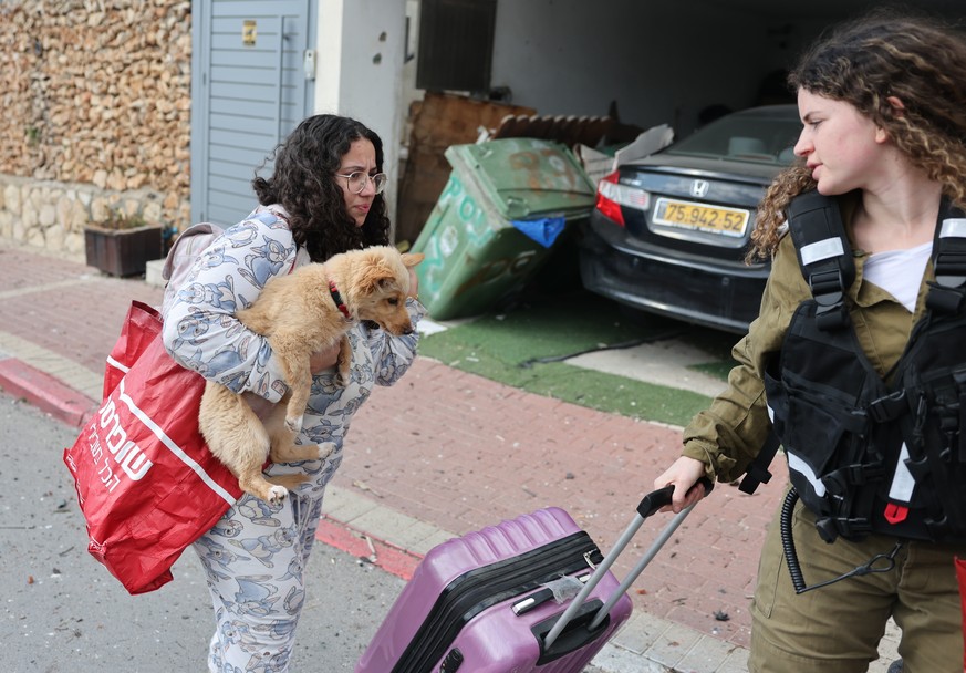 epa12787234 A girl with her dog is evacuated following an Iranian rocket attack that hit Beit Shemesh near Jerusalem, Israel, 01 March 2026. Israeli police confirmed at least six fatalities as a resul ...