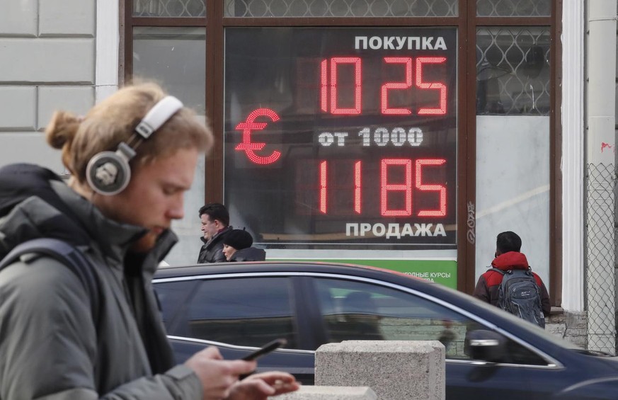 epa09791821 People walk in front of digital panel displaying the euro and US dollar currency rate at an exchange office in St. Petersburg, Russia, 28 February 2022. Russian Central Bank on 28 February ...