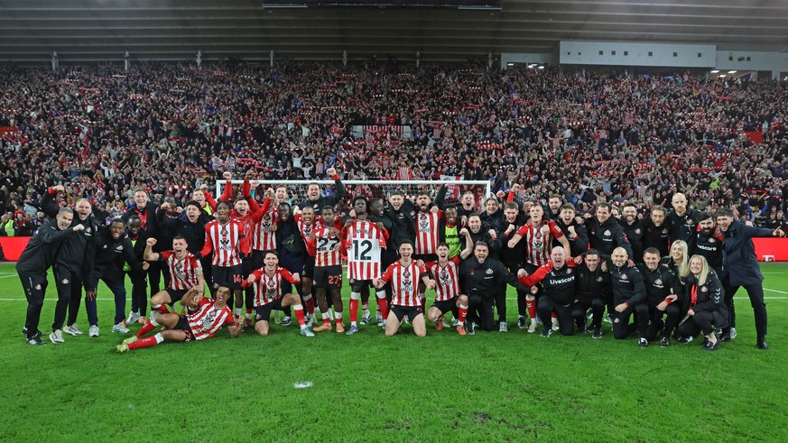 SUNDERLAND, ENGLAND - DECEMBER 14: The Sunderland team and staff celebrate the win on the final whistle during the Premier League match between Sunderland and Newcastle United at Stadium of Light on D ...