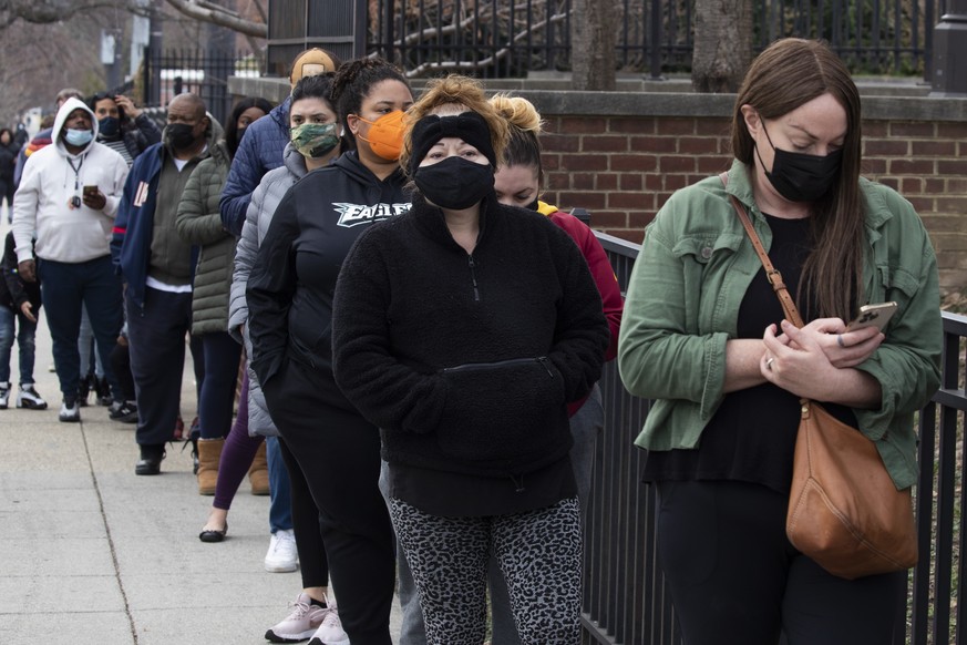 epa09660086 Hundreds of people wait in a line as the District of Columbia hands out free Covid-19 at-home antigen rapid tests at a library in Washington, DC, USA, 29 December 2021. The omicron variant ...