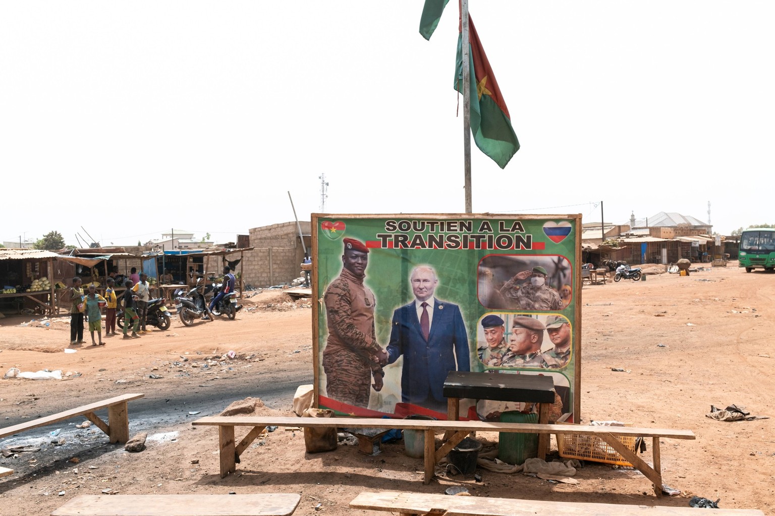 Eindr�cke aus Burkina Faso Burkina Faso, am Rande von Ouagadougou, 05.03.2024: An einer Strassenkreuzung mehrere Holzb�nke und ein Plakat vom Interimsstaatschef von Burkina Faso Ibrahim Traor� sch�tte ...
