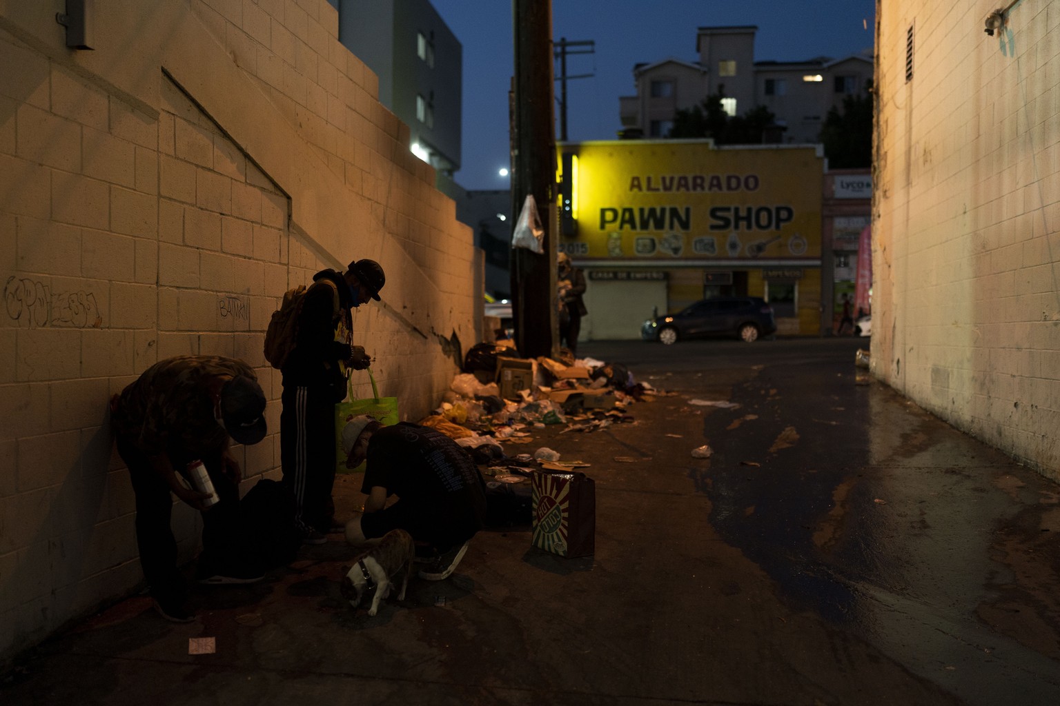 Drug addicts smoke fentanyl next to piles of trash in an alley in Los Angeles, Tuesday, Aug. 23, 2022. For too many people strung out on the drug, the sleep that follows a fentanyl hit is permanent. T ...