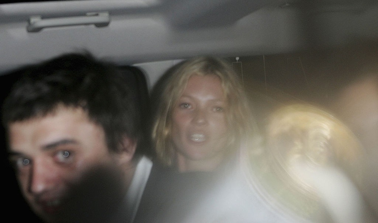 SOMERSET, UNITED KINGDOM - JUNE 24: Kate Moss in a car with, Pete Doherty throwing a full beer can to at photographers at the first day of the Glastonbury Music Festival 2005 at Worthy Farm, Pilton on ...