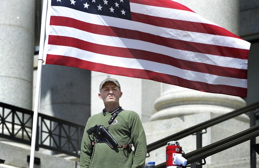 A man with a gun strapped to his chest stands at a gun rights rally organized by a group calling themselves Citizens and Students For Liberty (SFL), Saturday, April 14, 2018, at the Utah capitol in Sa ...