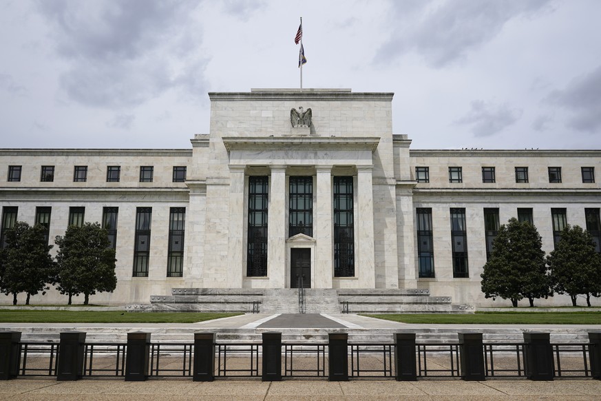 FILE - An American flag flies over the Federal Reserve building on May 4, 2021, in Washington. In statements made Thursday, Feb. 22, 2024, several Federal Reserve policymakers warned against cutting U ...