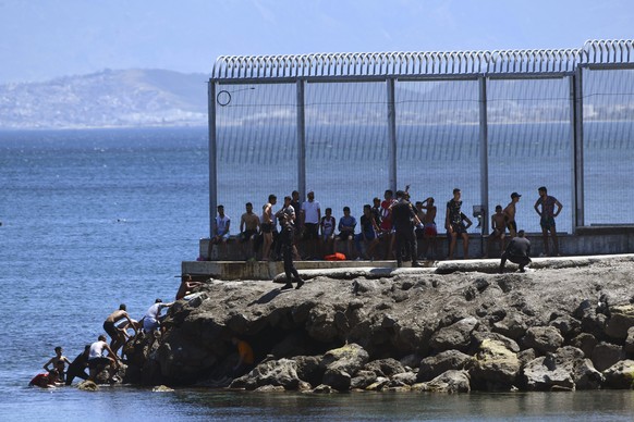 Spanish Guardia Civil officers try to stop people from Morocco entering into the Spanish territory at the border of Morocco and Spain, at the Spanish enclave of Ceuta on Monday, May 17, 2021. Authorit ...