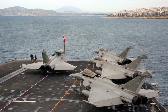 epaselect epa12028622 Rafale fighter aircraft on the deck of the nuclear powered air carrier of France, ?Charles de Gaulle?, which is anchored off the port of Piraeus on 12 April 2025 (issued on 13 Ap ...