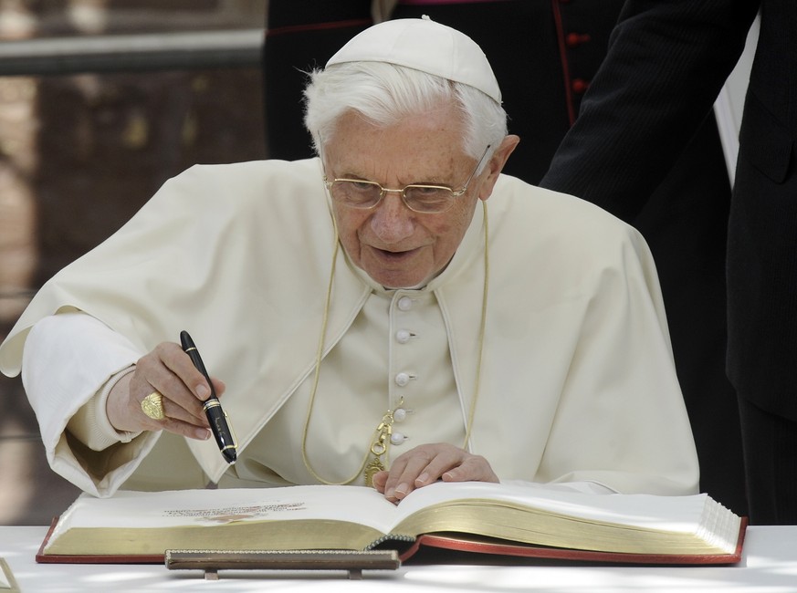 FILE - Pope Benedict XVI signs the golden book of Freiburg in front of the cathedral in Freiburg, Germany, on Sept. 24, 2011. When Cardinal Joseph Ratzinger became Pope Benedict XVI and was thrust int ...