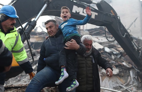 epa10453979 Eight-year-old Yigit Cakmak (C) reacts after being rescued from the site of a collapsed building, some 52 hours after a major earthquake, in Hatay, Turkey, 08 February 2023. More than 7,00 ...