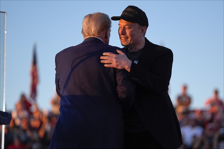 Republican presidential nominee former President Donald Trump hugs Elon Musk at a campaign rally at the Butler Farm Show, Saturday, Oct. 5, 2024, in Butler, Pa. (AP Photo/Evan Vucci)