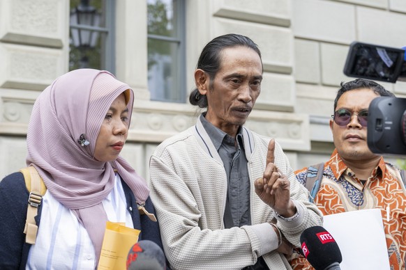 epa12348220 The plaintiffs from Indonesia, Ibu Asmania (L) and Arif Asmania (R) answer questions from the media in front of the court and government building during the main hearing in the case of Ibu ...
