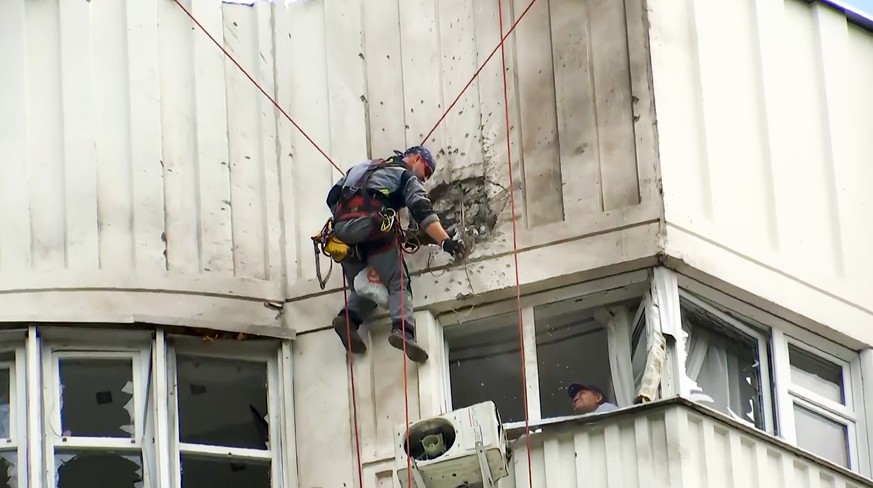 In this image taken from video, investigators inspect the building after a Ukrainian drone damaged an apartment building in Moscow, Russia, Tuesday, May 30, 2023. In Moscow, residents reported hearing ...