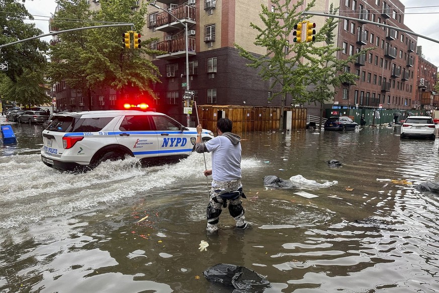A man works to clear a drain in flood waters, Friday, Sept. 29, 2023, in the Brooklyn borough of New York. A potent rush-hour rainstorm has swamped the New York metropolitan area. The deluge Friday sh ...