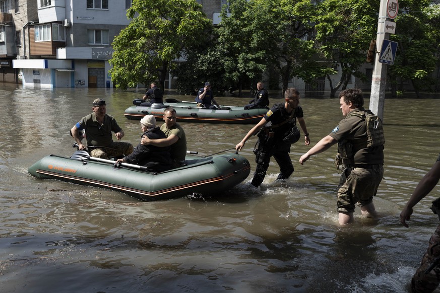 A woman is evacuated from a flooded neighborhood in Kherson, Ukraine, Wednesday, June 7, 2023 after the Kakhovka dam was blown up. Residents of southern Ukraine braced for a second day of swelling flo ...