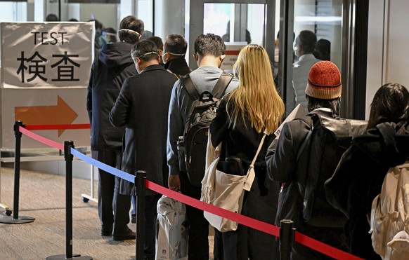 Des passagers arrivés de Shanghai font la queue pour se faire tester à Tokyo.