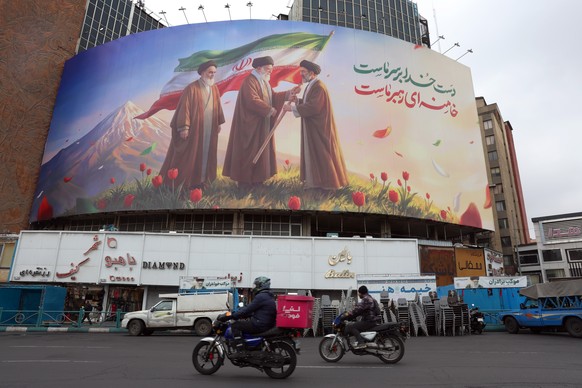epa12808836 People drive past a huge billboard showing the late Iranian supreme leaders Ayatollah?Ruhollah Khomeini?(L), Ayatollah?Ali?Khamenei?(C), and the new Iranian supreme leader Ayatollah?Mojtab ...