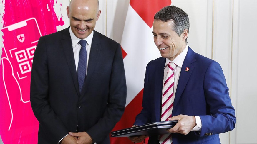 Swiss Federal President Alain Berset, left, and Ignazio Cassis, Swiss Minister of Foreign Affairs, right, after signing an agreement about investment in strategic entrepreneurship with Aurelien A. Agb ...