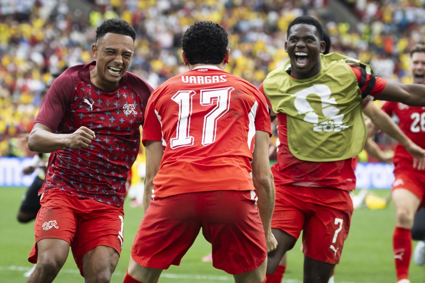 Switzerland's Ruben Vargas celebrates with teammates Dan Ndoye, left, and Breel Embolo after scoring the final penalty shot during the World Cup round of 16 soccer match between Switzerland and C ...