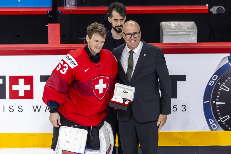 Switzerland&#039;s goaltender Leonardo Genoni #63 receives the award for the best Swiss player by Switzerland&#039;s Defense Minister Federal Councillor Martin Pfister, right, after the IIHF 2025 Worl ...