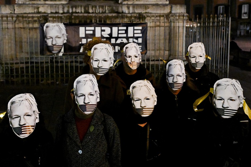 Des partisans de Julian Assange, fondateur de WikiLeaks, portant des masques, manifestent à Naples, en Italie.