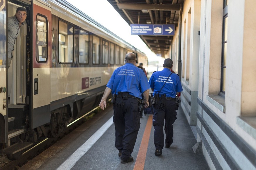 Members of the Swiss Border Guard Corps check a by train for persons who might have illegally entered Switzerland via rail from Italy, captured at the train station at the Swiss-Italian border in Chia ...