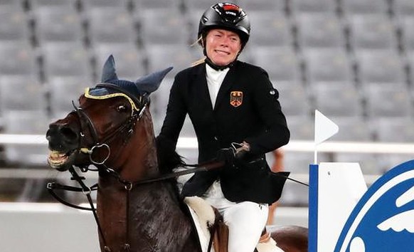 epa09400054 Annika Schleu of Germany on Saint Boy after hitting an obstacle as they compete in the Show Jumping portion of the Modern Pentathlon event at the Tokyo 2020 Olympic Games at the Tokyo Stad ...
